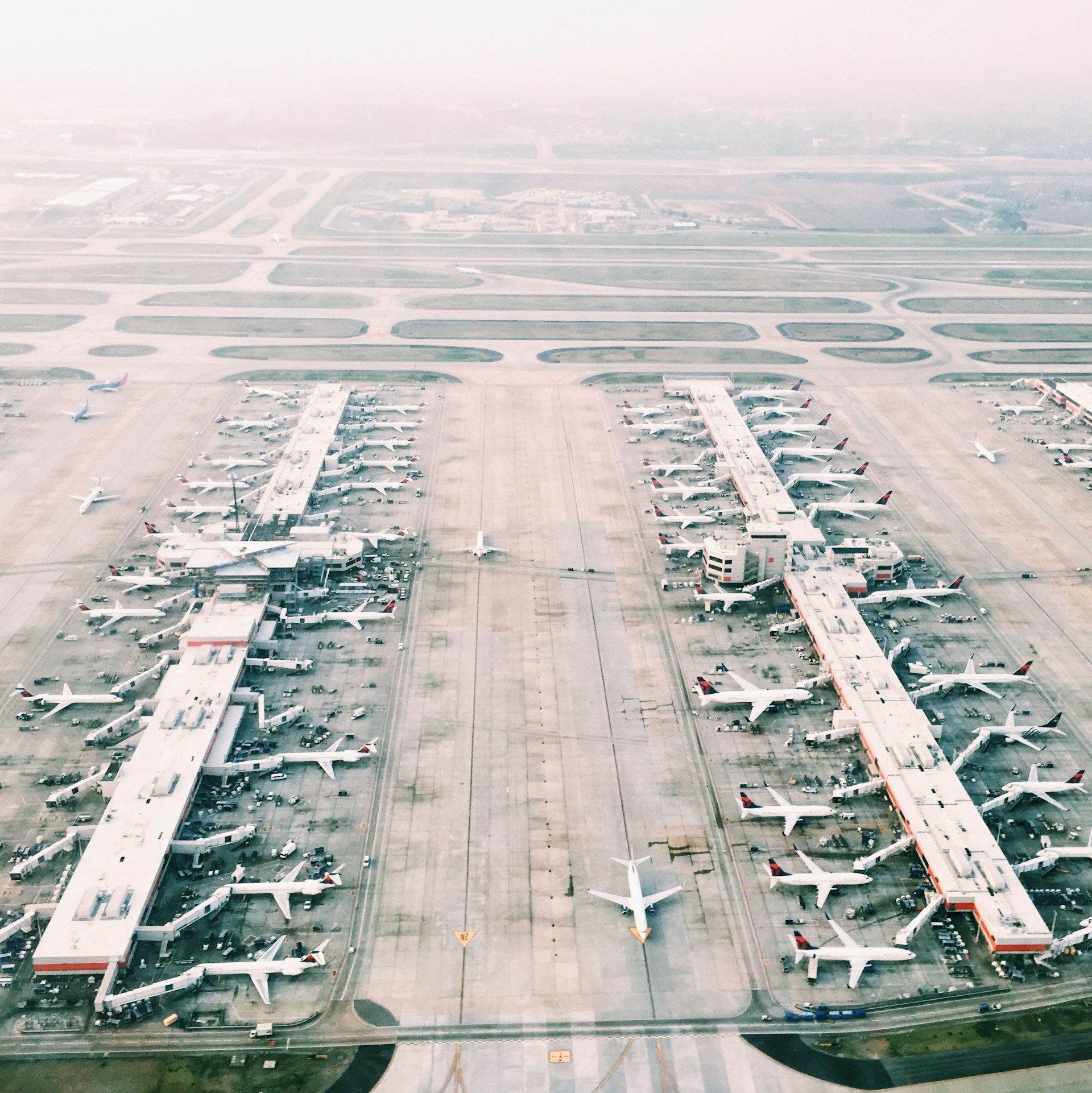 Aerial view of Atlanta Hartsfield-Jackson airport with multiple aircraft on runways and taxiways