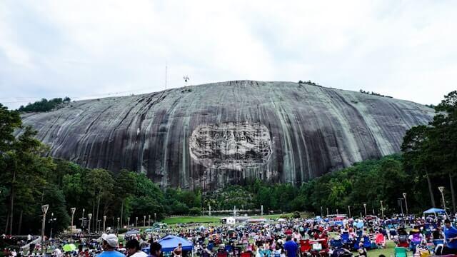 The Confederate memorial carving on Stone Mountain's granite face, with a crowd gathered below