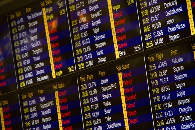 Airport departure board showing delayed and cancelled flights