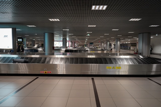 Empty airport baggage claim carousel with stainless steel conveyor and no bags on it